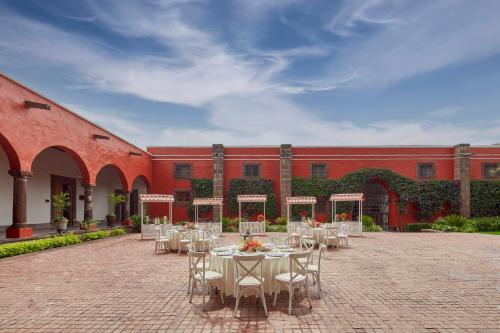 a courtyard with tables and chairs in front of a building at Fiesta Americana Hacienda Galindo Resort & Spa in Galindo