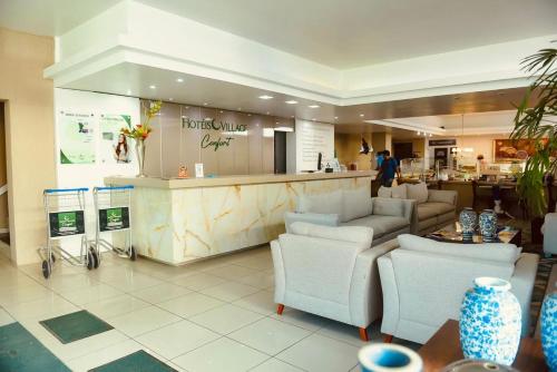Un restaurante con un mostrador y sillas y un bar. en Hotel Village, en Garanhuns