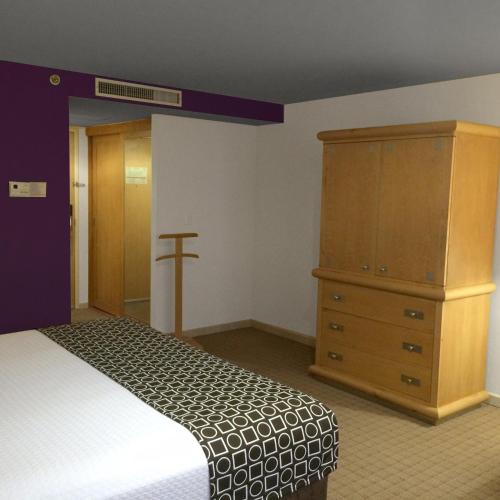 a bedroom with a bed and a wooden dresser at Gamma by Fiesta Americ Xalapa Nubara in Xalapa