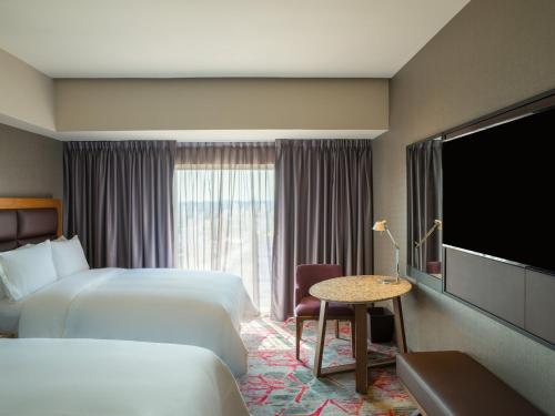 a hotel room with two beds and a flat screen tv at Fiesta Americana Mexico Toreo in Mexico City