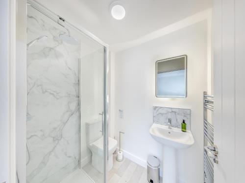a white bathroom with a shower and a sink at No 7 - Cheltenham - Uk47936 in Oswestry
