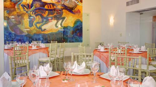 a room with tables and chairs with wine glasses at Fiesta Inn Villahermosa Cencali in Villahermosa