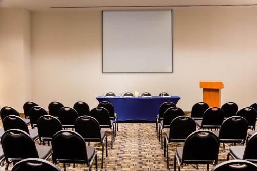a conference room with a blue table and chairs at Fiesta Inn Aguascalientes Patio in Aguascalientes