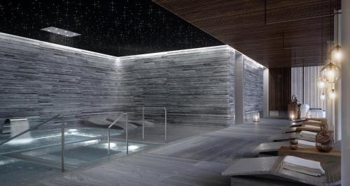 a bathroom with a tub and a stone wall at Live Aqua Monterrey in Monterrey