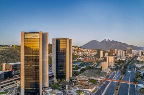 a city with two tall buildings and a street at Live Aqua Monterrey in Monterrey