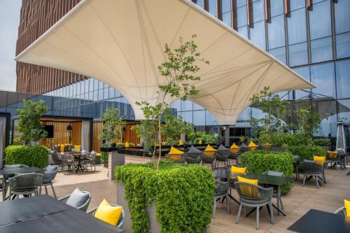 a restaurant with tables and chairs and a large white umbrella at Fiesta Americana Viaducto Aeropuerto in Mexico City