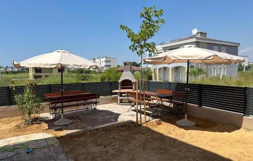 two tables and umbrellas in front of a house at Awesome Apartment In Privlaka With Wifi in Glavan