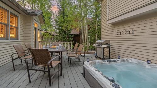 a hot tub on a deck with a table and chairs at Lansdowne Chateau in Breckenridge
