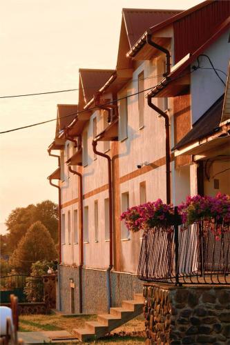a building with flower baskets on the side of it at AINO Hotel in Pilipets