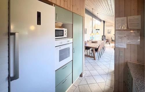 a kitchen with a refrigerator and a dining room with a table at Nice Home In Otterup With Kitchen in Otterup