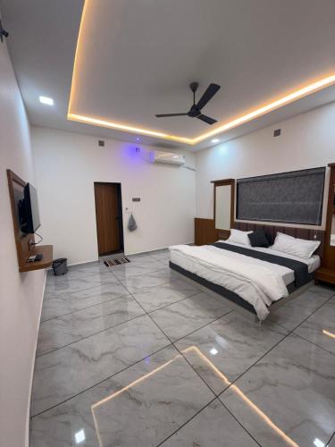a bedroom with a bed and a flat screen tv at Hotel Sunrise in Ādkot