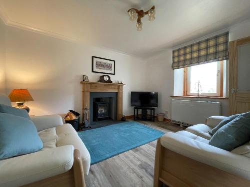 un salon avec deux canapés et une cheminée dans l'établissement Lag Cottage, à Dornie