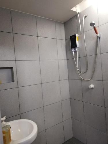 a bathroom with a shower and a sink at Mamay's Homestay in Tagbilaran City