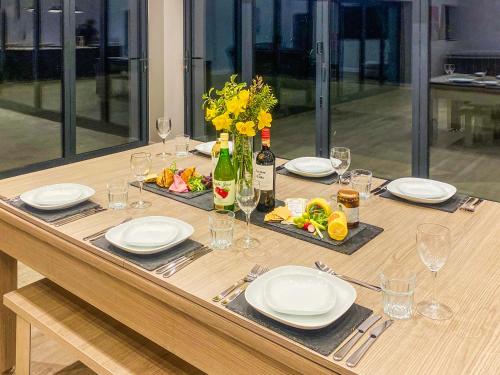 a table with plates and glasses and a bottle of wine at The Bungalow - Uk38049 in West Pennard