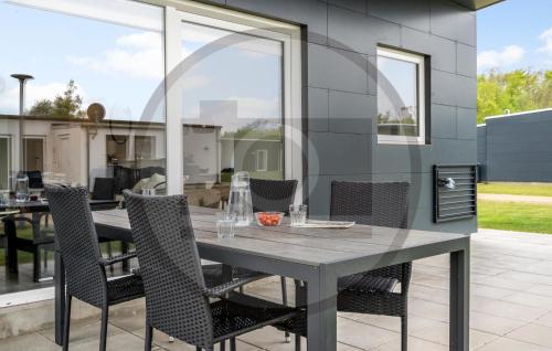 Una mesa de comedor y sillas en un patio. en Awesome Home In Ringkøbing With Wifi, en Hee