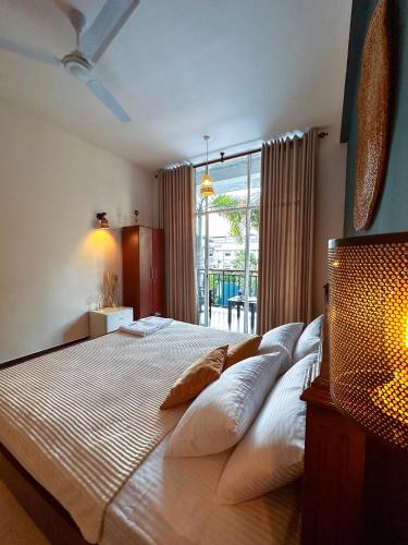 a bedroom with a large bed with white pillows at Santino Boutique in Mirissa