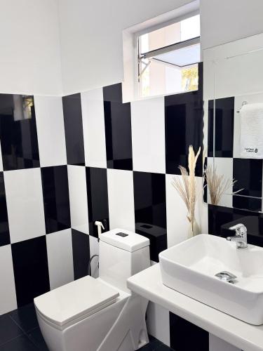a bathroom with a white toilet and a sink at Santino Boutique in Mirissa