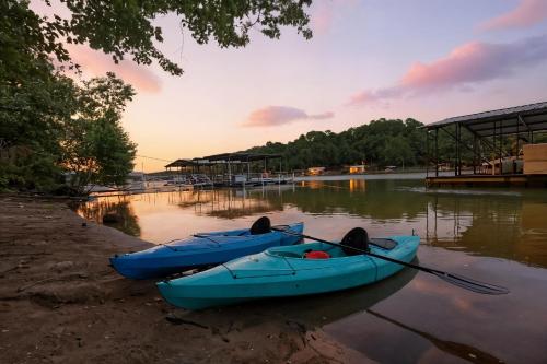 two blue boats sitting on the shore of a river at The Holiday House w Dock in Townville