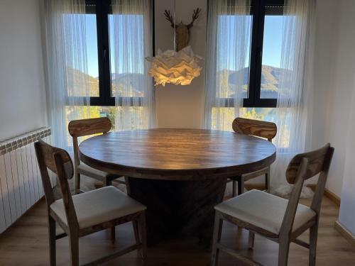 a dining room table with chairs and a wooden table at Casa Montaña de Riaño y Picos de Europa I in Riaño