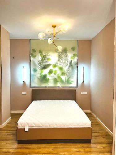 a bedroom with a bed with a painting on the wall at Квартира 17-23 in Aktau