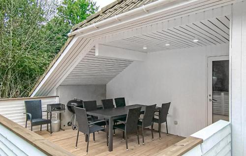 a patio with a table and chairs on a deck at Awesome Home In Oksbøl With Kitchen in Oksbøl