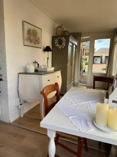 Una cocina con una mesa y una mesa blanca y un escritorio. en De kleine Bongerd -The little Orchard, en Hengelo