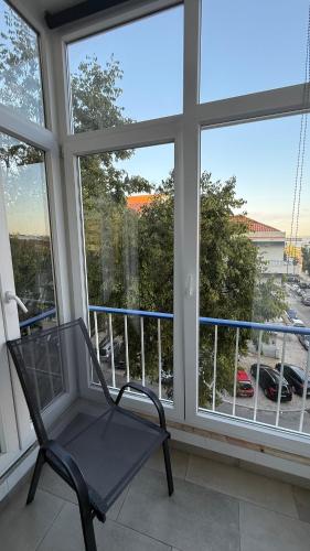 a black chair sitting on a balcony with windows at Quarto na Cova da Piedade in Almada