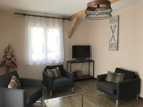 a living room with two chairs and a tv at Maison "L' Ostal De Montanha" in Génos