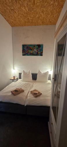 a bedroom with a white bed with two towels on it at Ferienhaus LODA - Garten, Netflix & Spreewald Flair in Heinersbrück