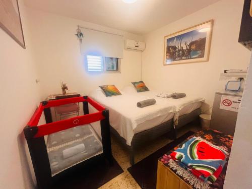 a small room with a bed and a refrigerator at The Lowest Place on Earth B&B in Neʼot HaKikar