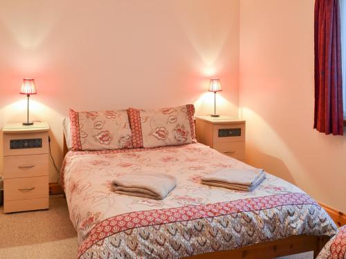 a bedroom with a bed with two night stands at Glen Apartment in Aviemore