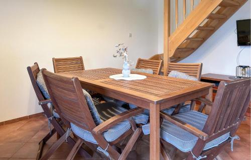 einen hölzernen Esstisch mit Stühlen und eine Treppe in der Unterkunft 3 Bedroom Cozy Home In Debina in Debina