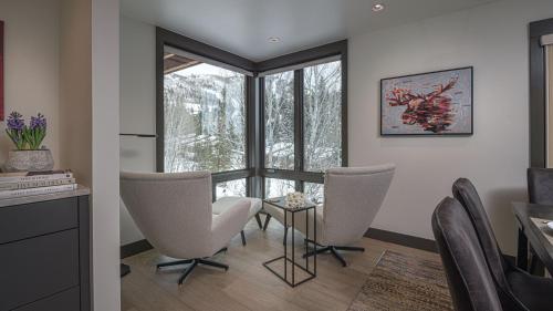 a living room with chairs and a table and a window at Orion Lodge in Steamboat Springs