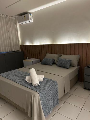 a bedroom with a bed with two towels on it at Pousada Mar de Maceió in Maceió