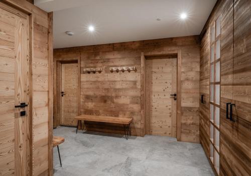 Habitación con paredes de madera y banco de madera. en Chalet Le Refuge Luxe Authenticité Serre Chevalier, en La Salle-les-Alpes