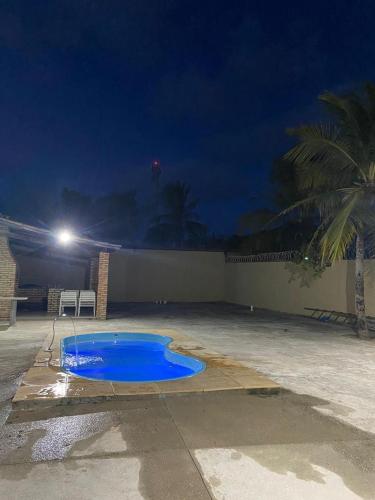 a blue swimming pool in a parking lot at night at Casa Brisas in Luis Correia