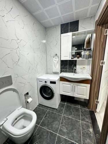 a bathroom with a toilet and a washing machine at Renaissance Apart Hotel in Trabzon