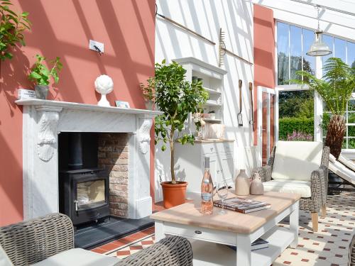 a patio with a fireplace and a table and chairs at The Garden Rooms in Montrose