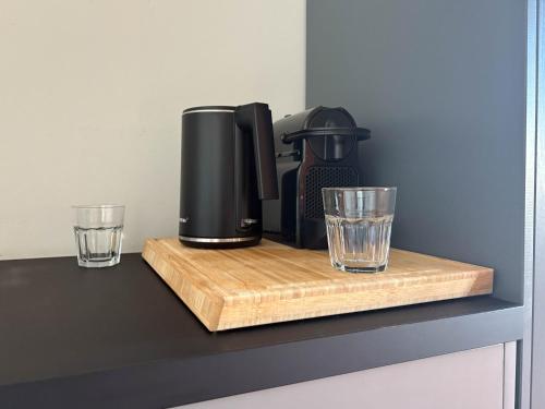 a coffee maker and two glasses on a counter at Studios am Hafen in Stralsund