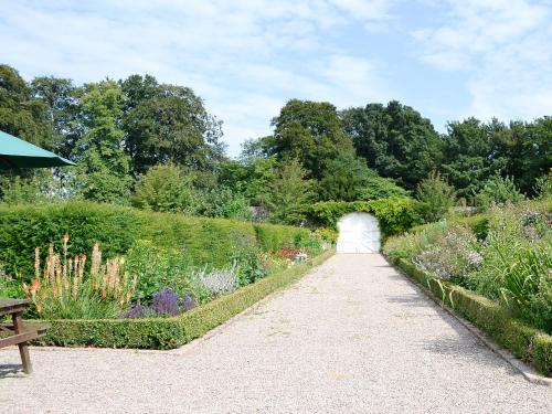 a path through a garden with flowers and bushes at The Garden Rooms in Montrose
