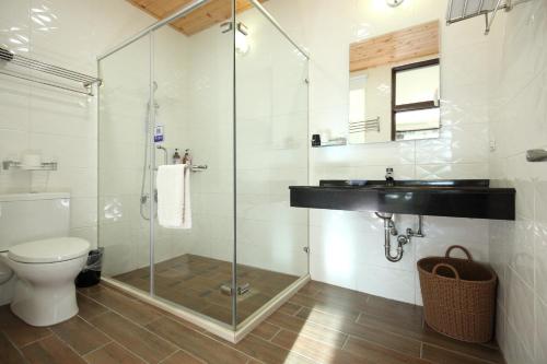 a bathroom with a shower and a sink and a toilet at Normans B&B in Hualien City