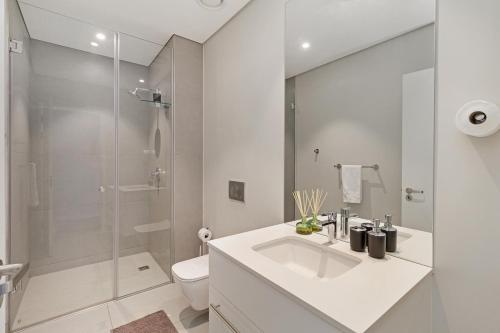 a white bathroom with a sink and a shower at 2 Bed Executive Apartment Table Mountain views in Cape Town