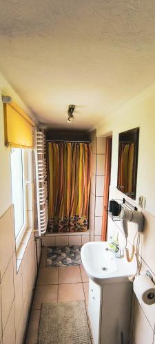 a small bathroom with a sink and a window at Pokoje Pod Cyrlicą u Józi in Chochołów