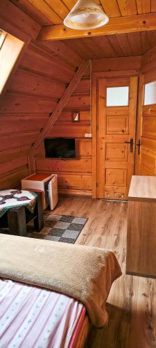a room with a bed in a wooden cabin at Pokoje Pod Cyrlicą u Józi in Chochołów