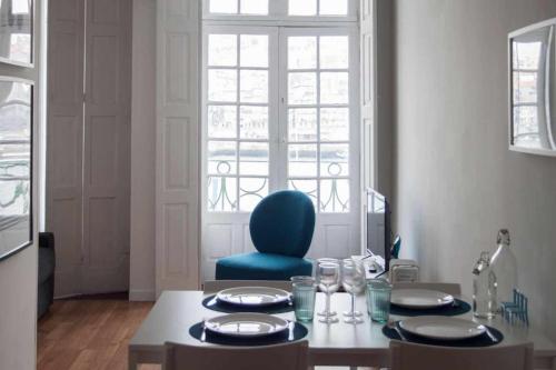a dining room with a table and a blue chair at Panorama Apartments Ribeira Gaia in Vila Nova de Gaia