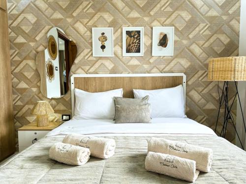 een slaapkamer met een groot wit bed met twee kussens bij Ochi Houses - Ain drahem in Ain Draham