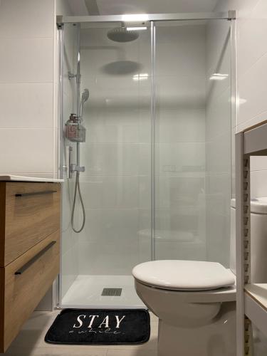 a bathroom with a shower with a toilet and a sign at La Cabañita de Leiva in Leiva