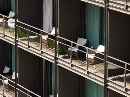 a window of a building with tables and chairs at Sofitel Barcelona Skipper in Barcelona