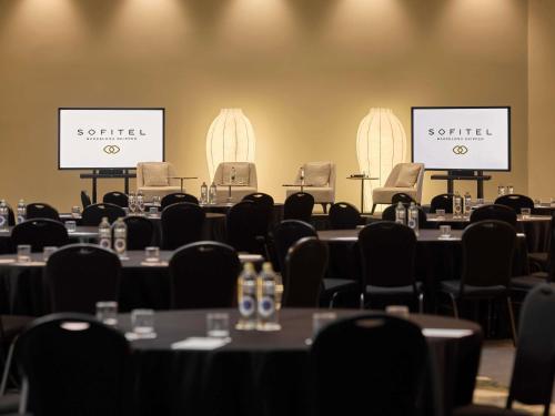 a conference room with tables and chairs and screens at Sofitel Barcelona Skipper in Barcelona