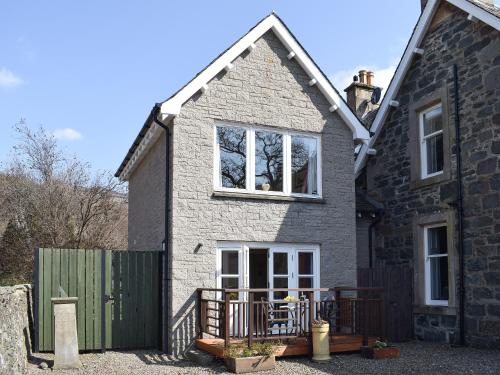 a house with a green gate and a fence at Lochearnside Lodge in Saint Fillans